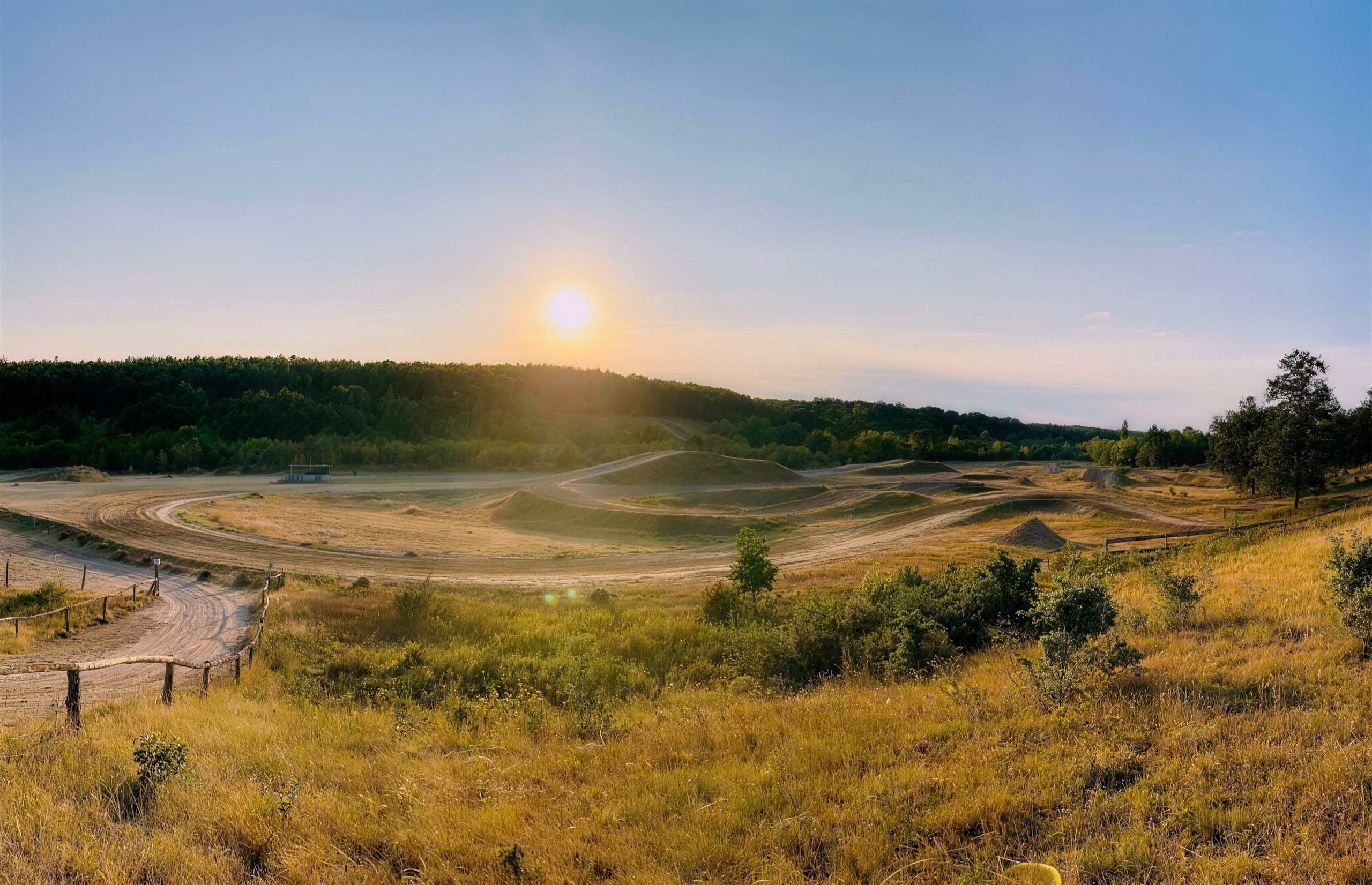 Blick vom Hang über die gesamte Motocross-Strecke im Abendlicht